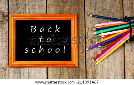 Back to school. Frame and pencils. Vertically. A wooden background.
