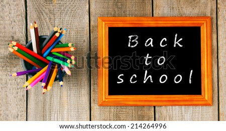Back to school. Frame and pencils. Vertically. A wooden background.