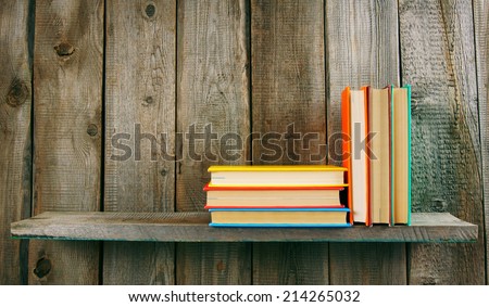 Books on a wooden shelf. On a wooden background.