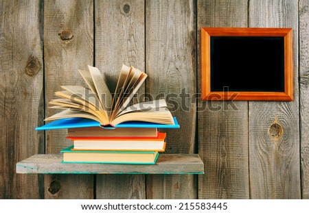 Back to school. The open book on a wooden shelf. A wooden background.