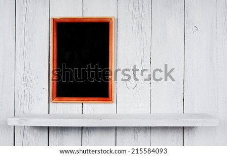 Back to school. Frame and a wooden shelf. A white, wooden background.