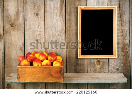 Apricots in a box on a wooden shelf. A framework on a wooden background.
