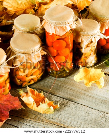 Autumn concept. Preserved food in glass jars on a wooden board. Marinated food