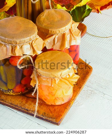 Autumn concept. Preserved food in glass jars on a wooden board. Marinated food