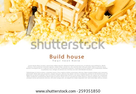 Woodworking. House construction. Joiner\'s works. The wooden house, chisel, plane and shaving on white background.
