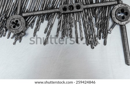 Metal tools. Metal style. Drills on the scratched metal background.
