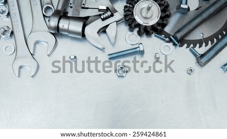 Metal working tools. Metal style. Metal tools and fixing elements on the scratched metal background.