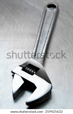 Metal tools. Metal style. Wrench on the scratched metal background.