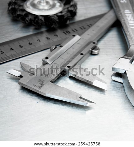 Metal style. Ã�Â¡alliper and other metal tools on the scratched metal background.