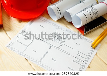 Planning of repair of apartment. Repair work. Drawings for building, helmet, pencils and others tools on wooden background.