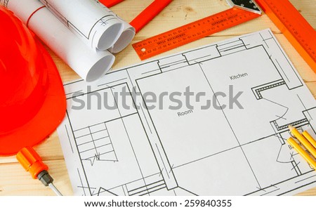 Planning of repair of apartment. Repair work. Drawings for building, helmet, pencils on wooden background.