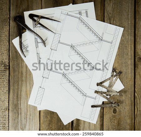 House construction. Many drawings for building and old working tools on old wooden background.