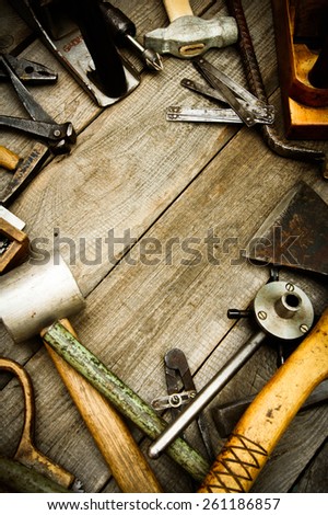 Old working tools. Vintage working tools (drills, plane, hammer and others) on wooden background.