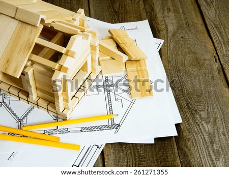 Building house. House construction. Many drawings for building and wooden house on old wooden background.