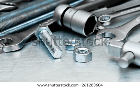 Metal working tools. Metal style. Metal tools and fixing elements on the scratched metal background.