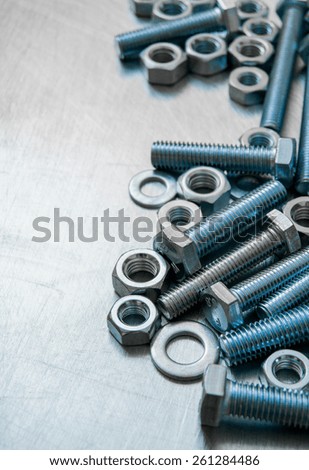 Metal style. Fixing elements. Nuts, washers and bolts on scratched metal background.