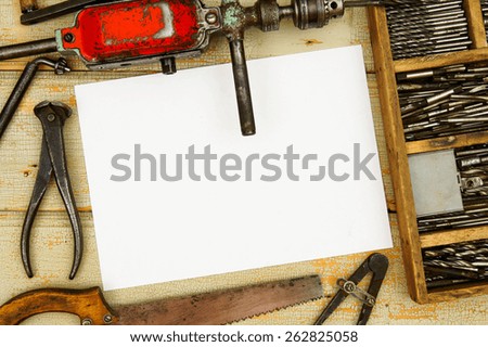 Old working tools. Paper with pencil and the vintage working tools on wooden background.