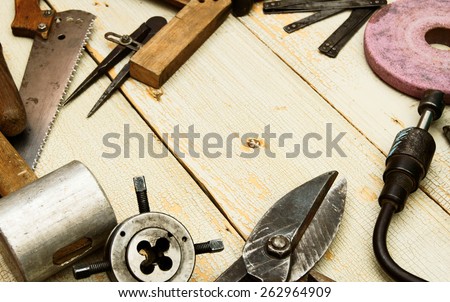 Old working tools. Vintage working tools (scissors, mallet, hammer and others) on wooden background.