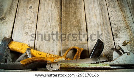 Old working tools. Many old tools ( axe, saw and others) on a wooden shelf.
