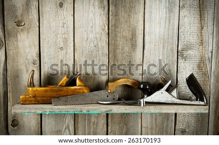 Old working tools. Many old tools (plane, mallet and others) on a wooden shelf.