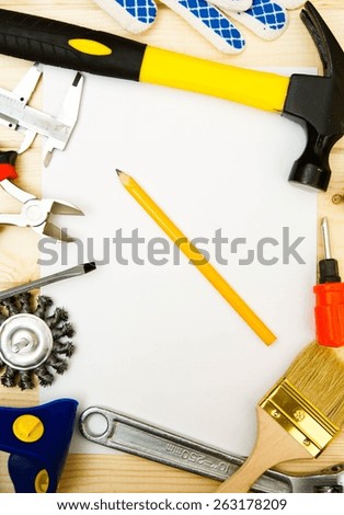 Workng tools. Paper for notes and set of working tools (hammer, gloves and others) on wooden background.