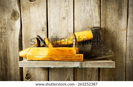 Old working tools. Many old tools (axe, plane and others) on a wooden shelf.