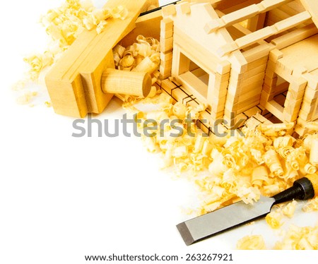 Woodworking. House construction. Joiner\'s works. The small wooden house, chisel, plane and shaving on white background.