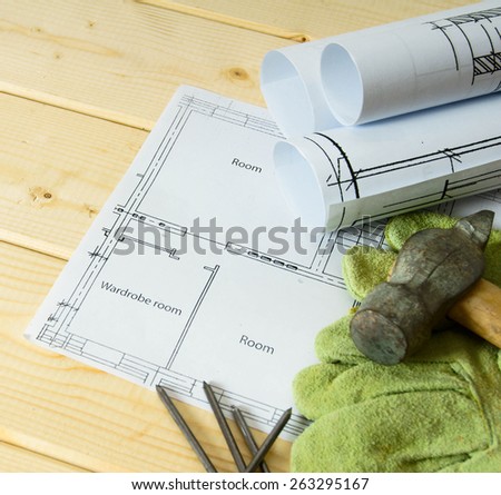 Planning of repair of the house. Repair work. Drawings for building, hammer and gloves on wooden background.