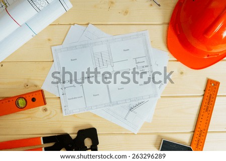 Planning of construction of the house. Repair work. Drawings for building, helmet, pencils and others tools on wooden background.