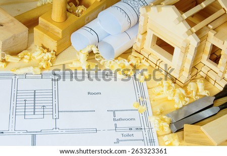 Planning of repair of the house. Woodworking. Drawings for building, small wooden house and working tools on wooden background.