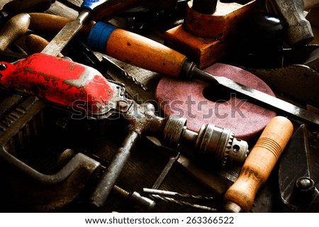 The old working tool. Many old working tools ( ruler, drill, chisel and others) on a wooden background.