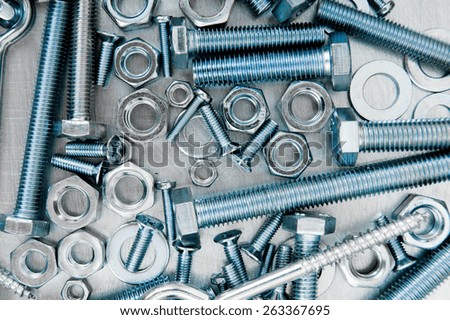 Metal style. Fixing elements. Nuts, screws and bolts on scratched metal background.