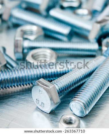 Metal style. Fixing elements. Nuts, screws and bolts on scratched metal background.