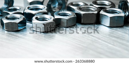 Metal style. Fixing elements. Nuts on scratched metal background.