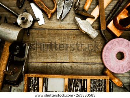 Old working tools. Vintage working tools (drills, plane, hammer and others) on wooden background.