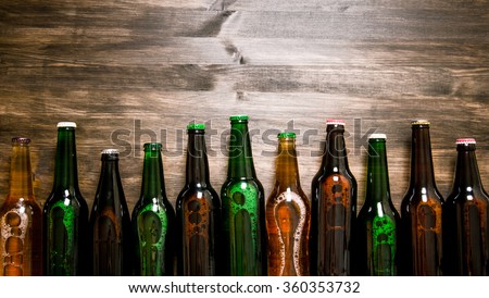 Beer bottles on a wooden table . Top view