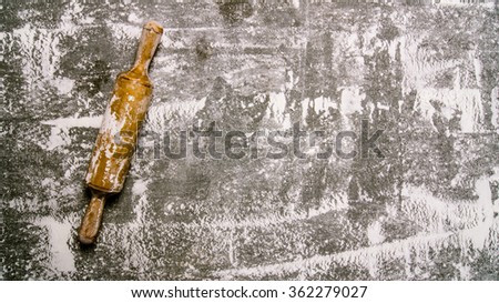 Baking background with a rolling pin with flour. On the stone table. Free space for text . Top view