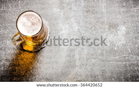 Beer in a glass on a old stone surface. Top view