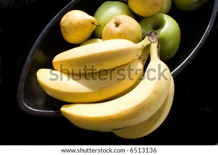 pears, apples and bunch of bananas in black Japanese vase isolated with white background 2