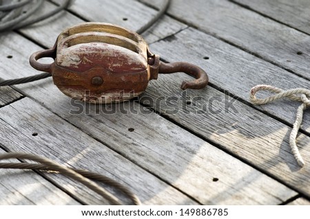 Rope and pulley (block and tackle) on a wooden sail boat deck