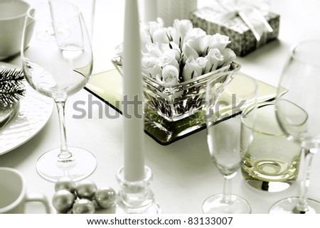 Christmas dinner table setting with roses and present