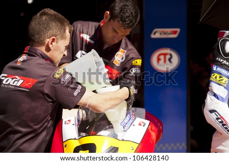 BARCELONA - SPAIN JUNE 24: Mechanics in the garage pouring gasoline on a bike for Moto2 race at 2012 Speed Championship in Spain at Montmelo circuit on June 24, 2012