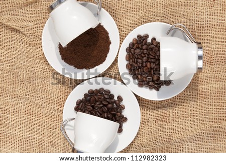 Cups with coffee beans and ground coffee