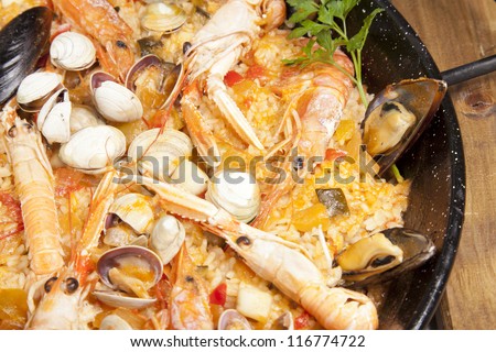 Paella rice with prawns cooked in a barbecue fire