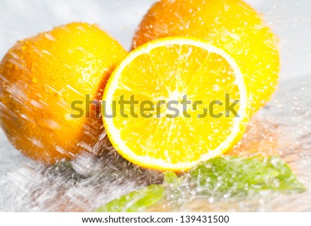 Fresh yellow orange splashing into water with water bubbles