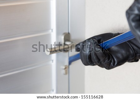 Thief With A Bar Of Iron In The Hand To Open A Door
