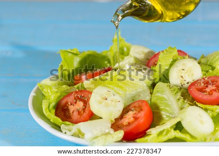 Fresh salad made up of lettuce, tomato and cucumber dressed with oil and oregano
