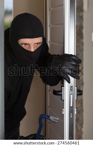 Thief entering a private home to steal