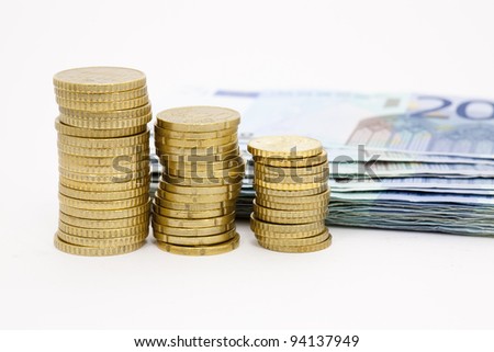 Euro notes and coins stacked on a white background