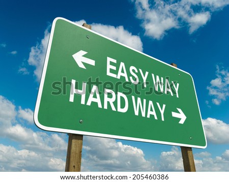A road sign with easy way hard way words on sky background